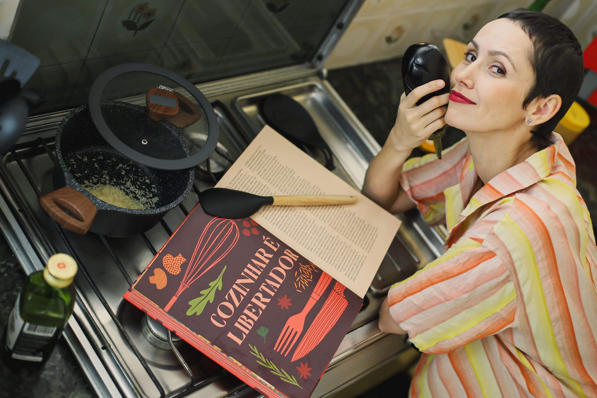 Júlia Menezes Nutricionista com um livro de receitas cozinhando